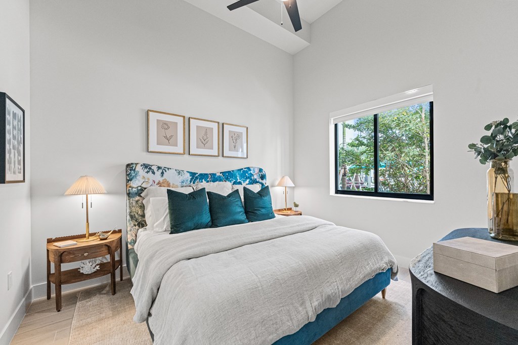 A bedroom with a large bed and a ceiling fan.