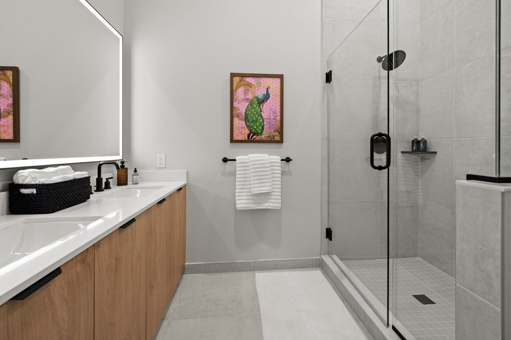 A bathroom with a white sink and a glass shower stall.