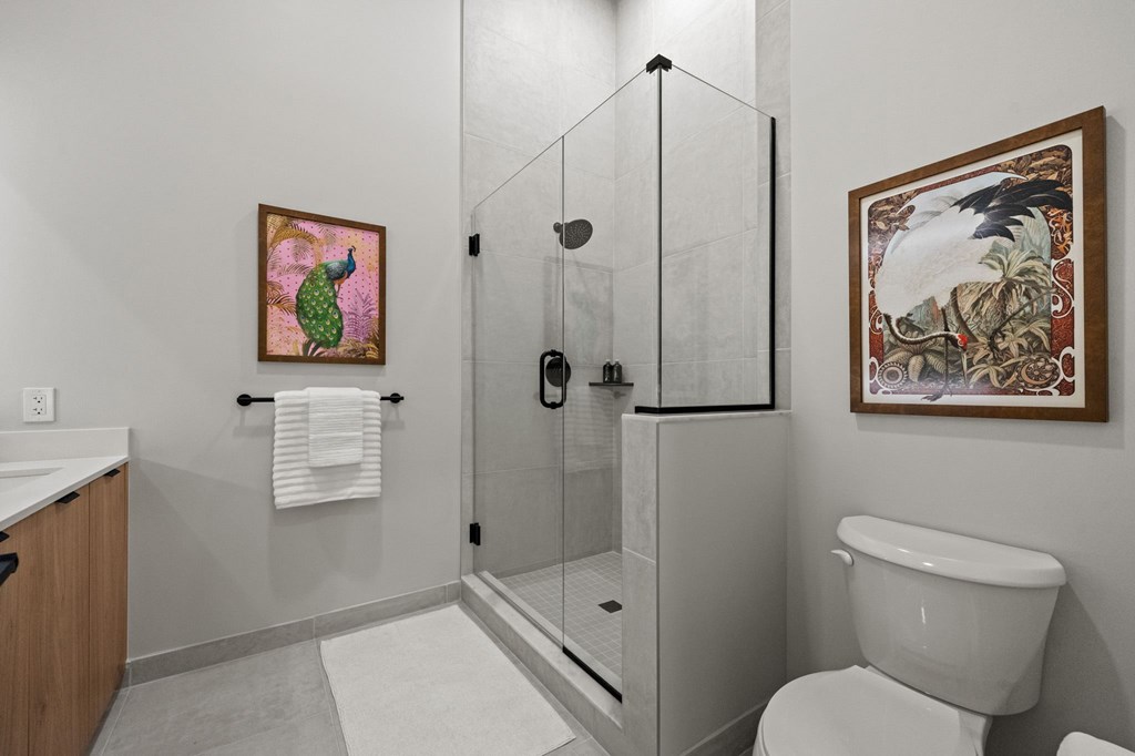 A bathroom with a toilet, a sink, and a shower with a glass door.