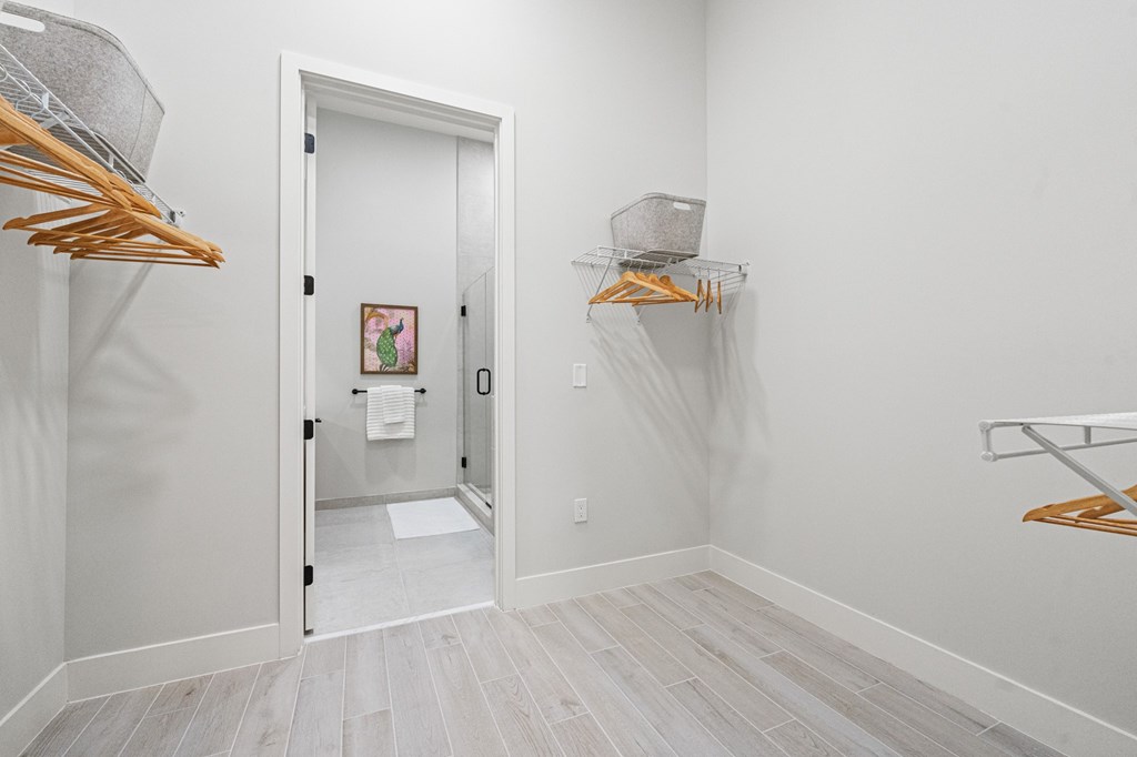 A white door is open to a hallway with a basket on the wall.