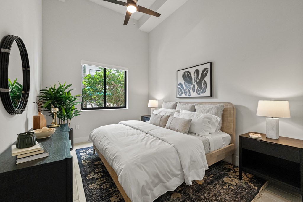 A bedroom with a large bed and a ceiling fan.