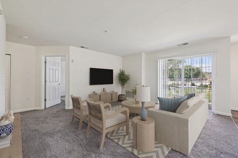 A living room with a grey carpet and a white sofa.