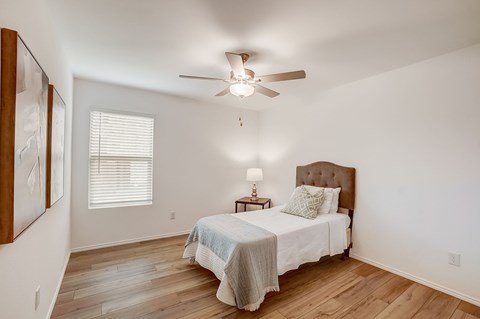 Cozy bedroom with hardwood floors, enhanced by the soft glow of natural light
