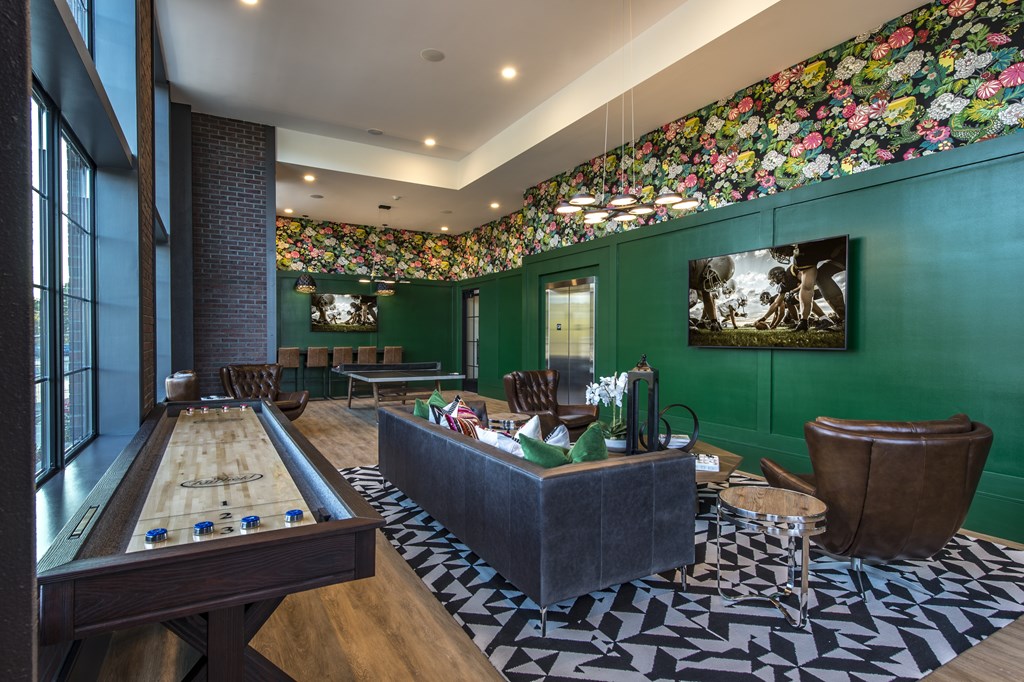 A room with a pool table and a green wall with a picture on it.