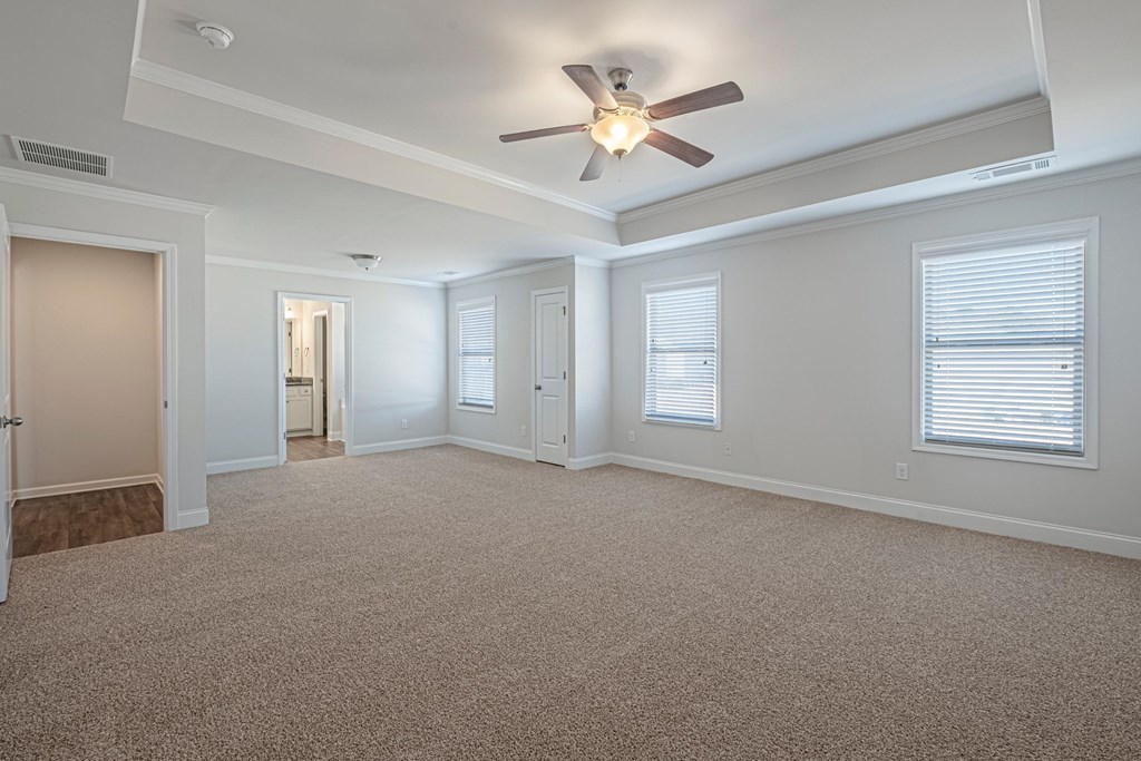 an empty living room with a ceiling fan and window