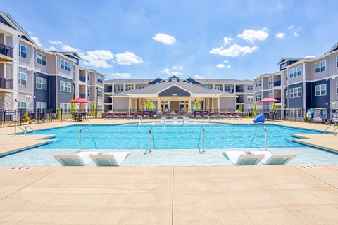 A large swimming pool in front of apartment buildings.