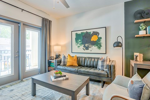 A living room with a grey sofa, a coffee table, and a painting on the wall.
