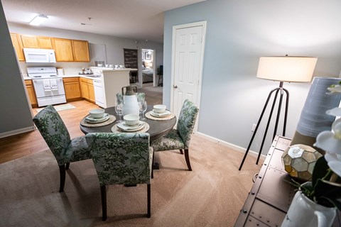 A dining room with a table set for four.