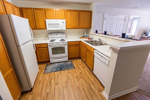 A kitchen with wooden cabinets and a white refrigerator.