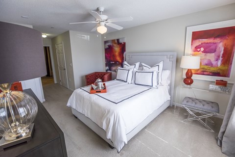 A bedroom with a large bed and a ceiling fan.