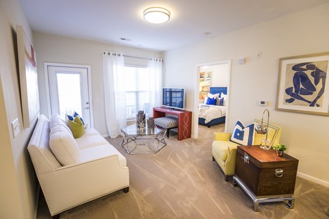 A living room with a white sofa and a wooden side table.