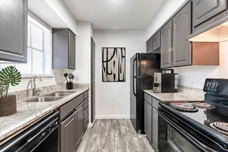 a kitchen with dark cabinets and white countertops