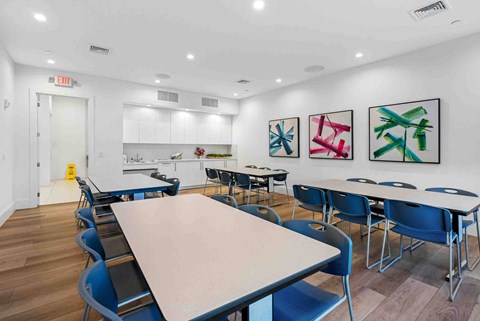 a dining room with tables and chairs and a kitchen