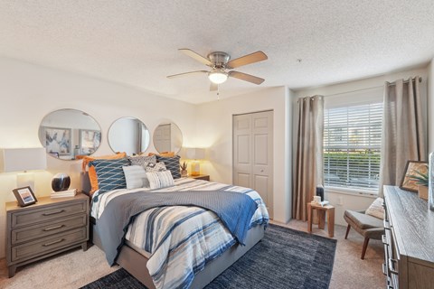 A bedroom with a large bed and a ceiling fan.