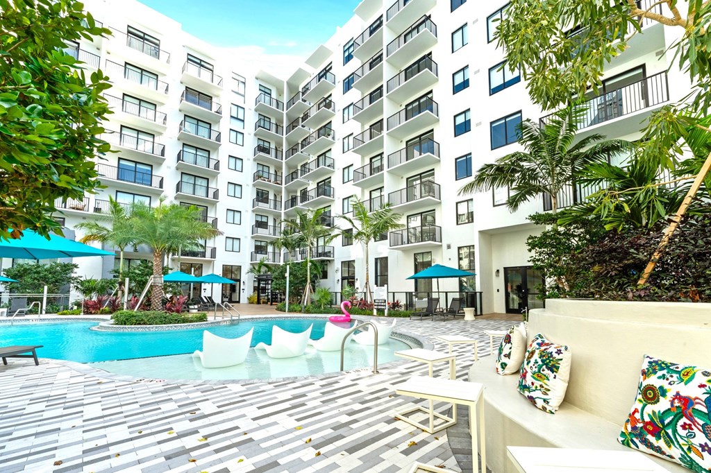 A large white building with a pool in front.