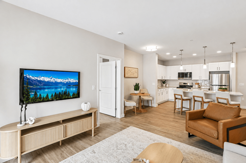 A modern living room with a flat screen TV and a wooden bench.