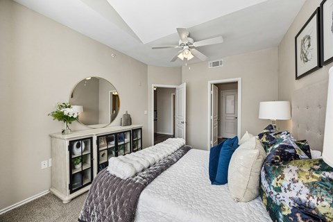 A bedroom with a large bed and a mirror on the wall.