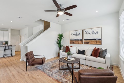 A living room with a brown leather chair and a white couch.