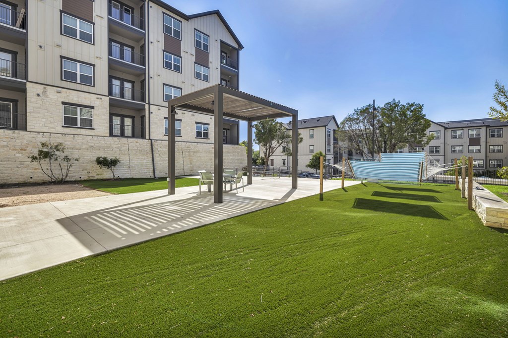 a green lawn in front of an apartment building