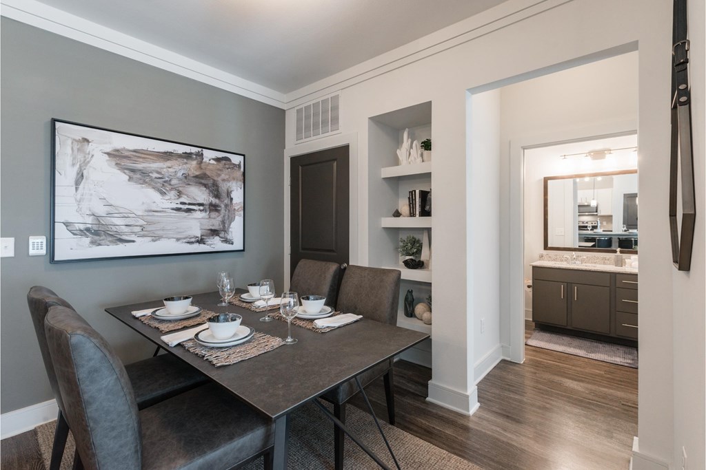 a dining room with a table and chairs and a painting on the wall