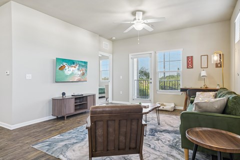 A living room with a brown wooden chair and a green sofa.