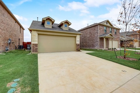 Expansive driveway with a well-kept lawn on both sides, leading to a two-car garage
