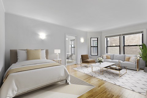A well-lit bedroom with a large bed and a couch.