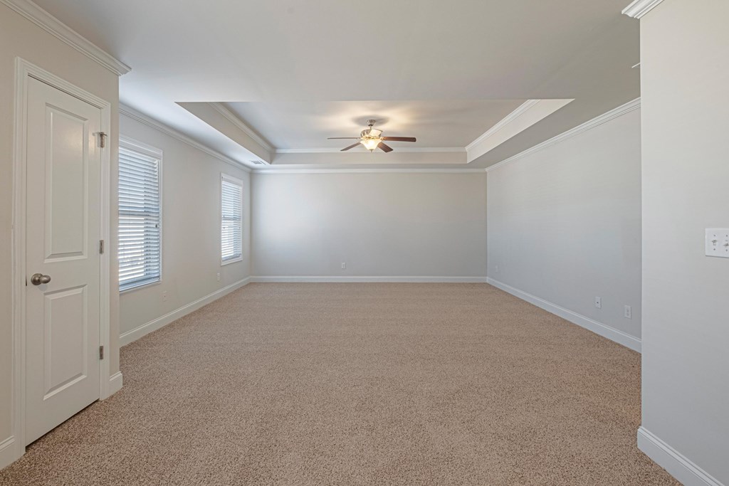an empty bedroom with a ceiling fan and a closet