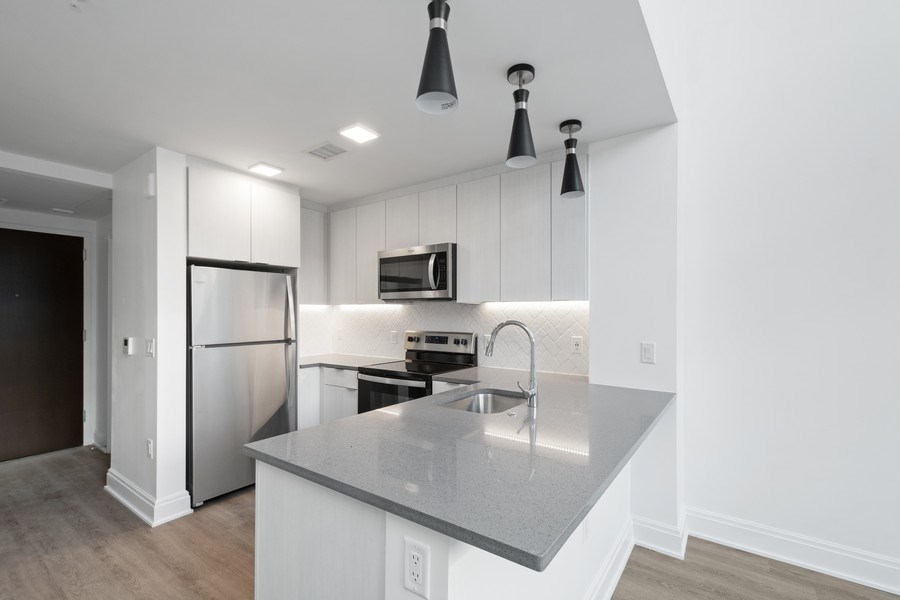 a renovated kitchen with white cabinets and stainless steel appliances