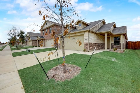 Expansive driveway with a well-kept lawn on both sides, leading to a two-car garage