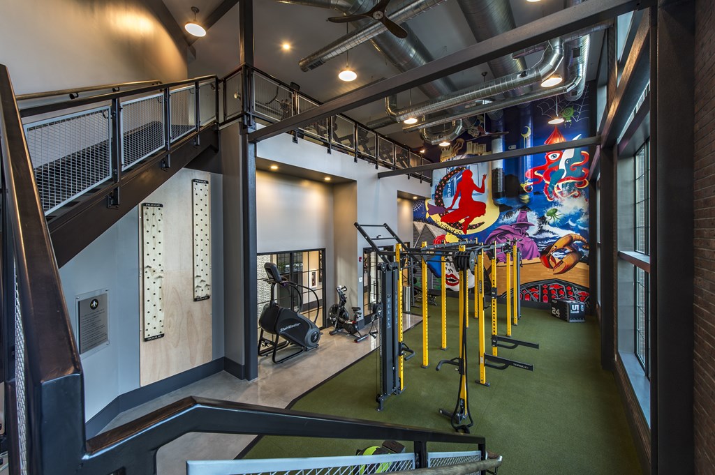 A gym with a green floor and a mural on the wall.