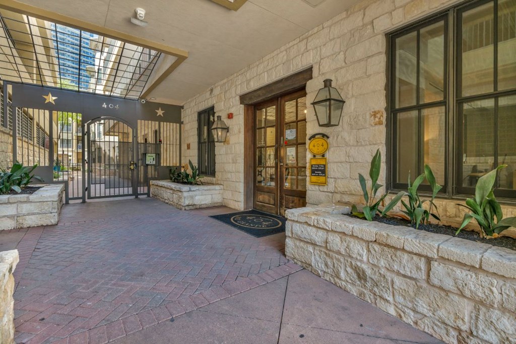 the entrance to a building with a stone wall and glass doors