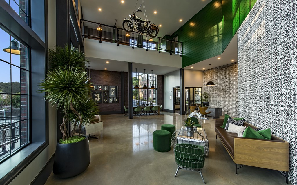 A modern living room with a green plant and a bicycle hanging from the ceiling.