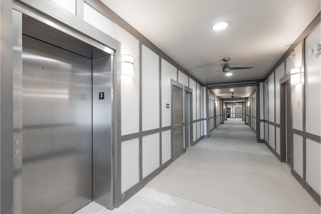 a corridor in a prison with rows of metal prison doors