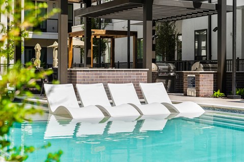 A pool with a white sunbed in the middle of it.