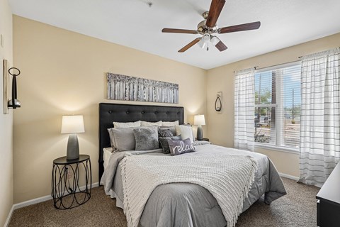 A bedroom with a large bed and a ceiling fan.