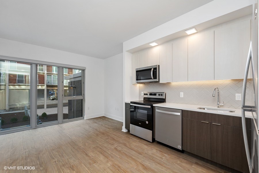 a living room with a kitchen and a sliding glass door
