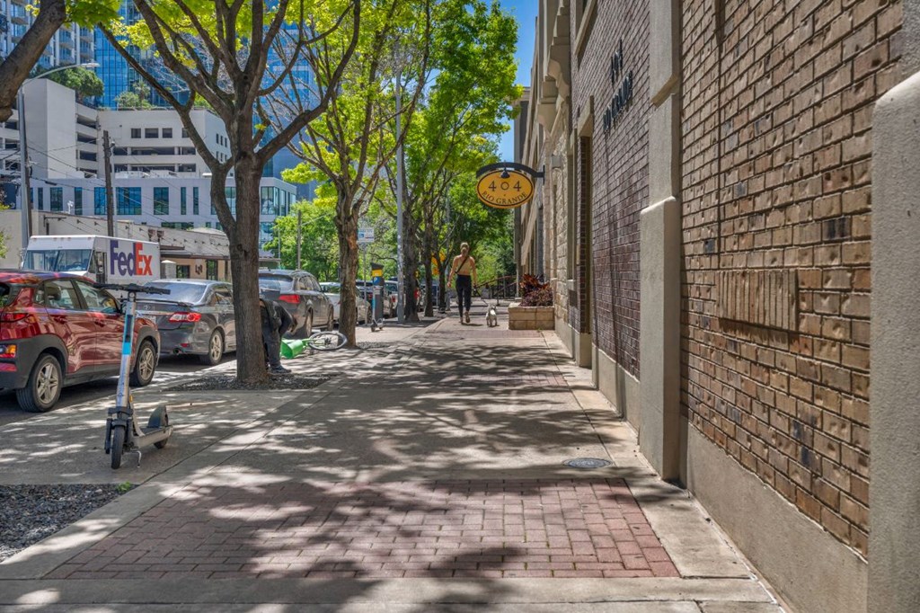 a city street with a brick building and a wheelchair on the sidewalk