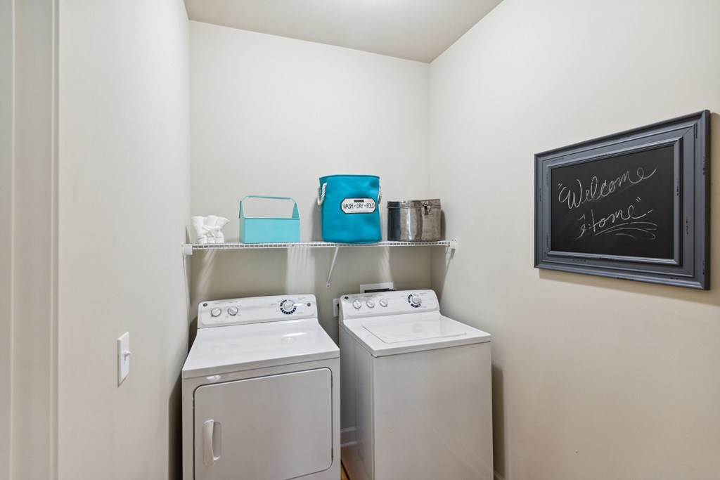 a washer and dryer in the laundry room at the enclave at woodbridge apartments in