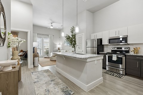 A modern kitchen with a large island and stainless steel appliances.