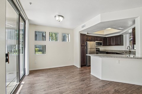 A kitchen with a white counter and brown cabinets.