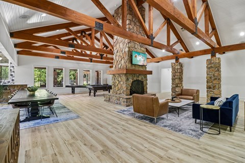 A living room with a stone fireplace and wooden beams.