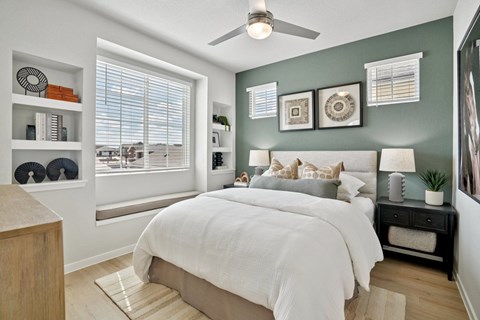 A bedroom with a large bed and a ceiling fan.