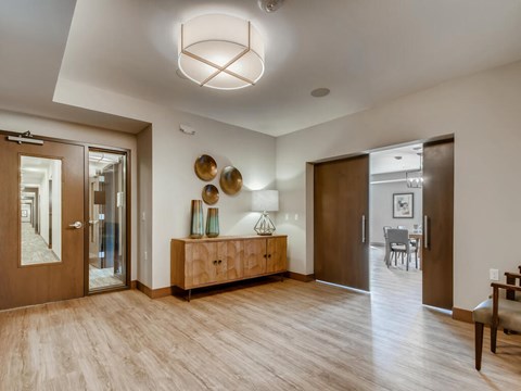 A modern living room with a wooden floor and a large wooden cabinet.