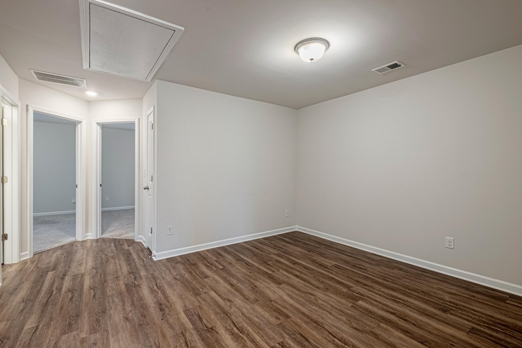 the living room and dining room of a new home with wood floors and white walls
