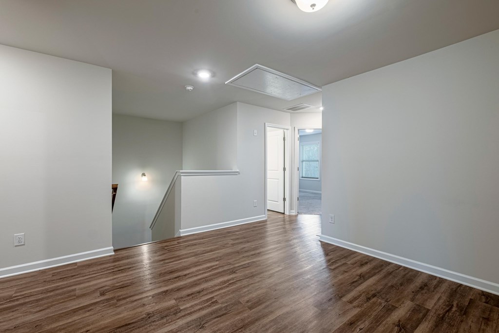 a living room with a hard wood floor and white walls