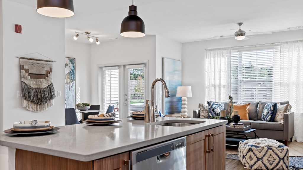Kitchen island with view of living and dining room with large windows in background