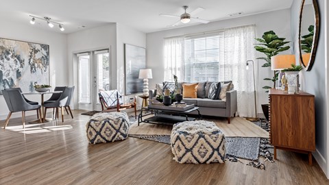 A living room with a grey couch, a wooden cabinet, and a rug on the floor.