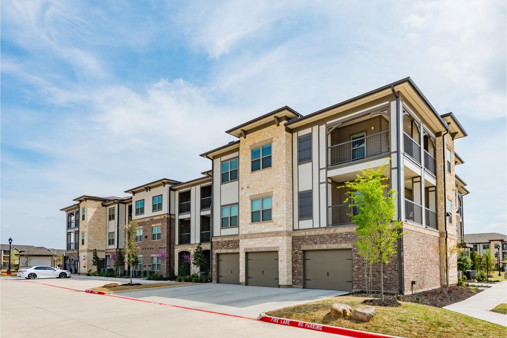 a row of brick apartment buildings with garage doors