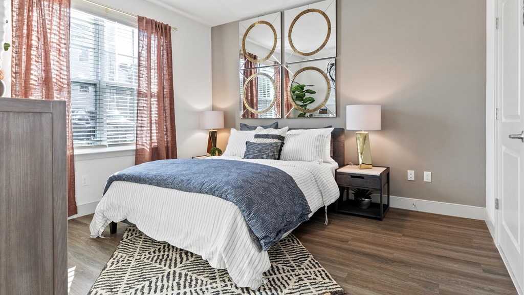 Bedroom with woodstyle flooring and large windows